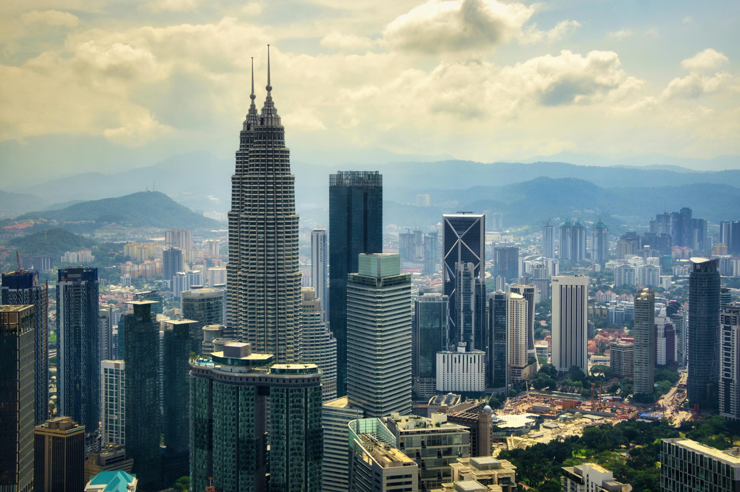 Contact A stunning aerial view of Kuala Lumpur's skyline highlighting the iconic Petronas Towers.